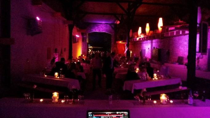 Party Lokhalle Gemütliches Restaurant mit Kerzenlicht und bunten Lichtern, voll von Gästen.