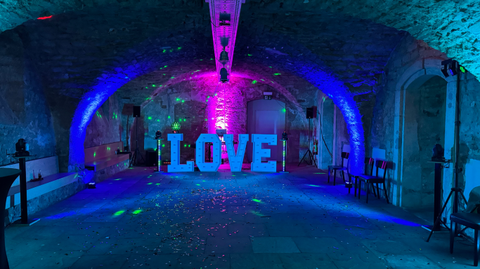 Gewölbekeller Futuristische Eventlocation mit bunten Lichtern und einem großen "LOVE"-Schild.
