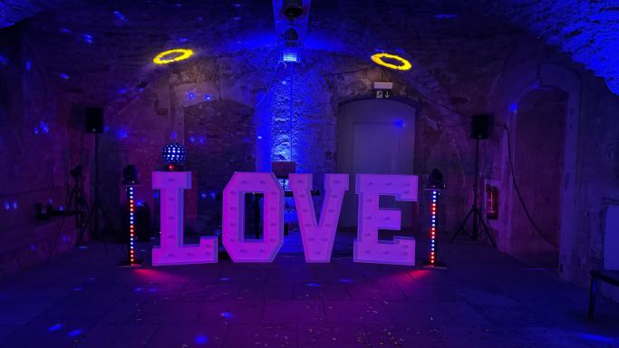 Gewölbekeller Große, beleuchtete Buchstaben „LOVE“ in einem stimmungsvoll beleuchteten Raum.