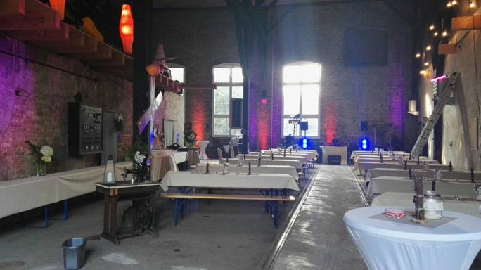 Aufbau Lokhalle Ein stilvoll dekorierter Veranstaltungsraum mit Tischen und sanfter Beleuchtung.